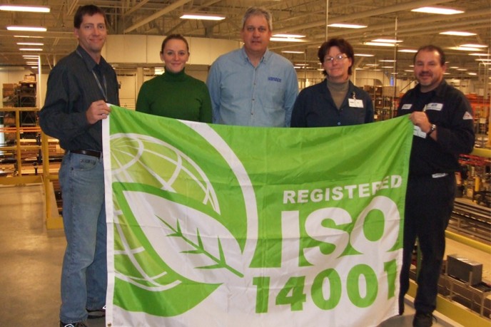 Kondex staff holding up a green ISO 14001 flag