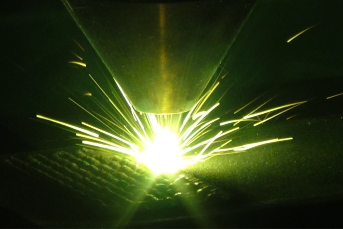 Green laser with sparks on a black background