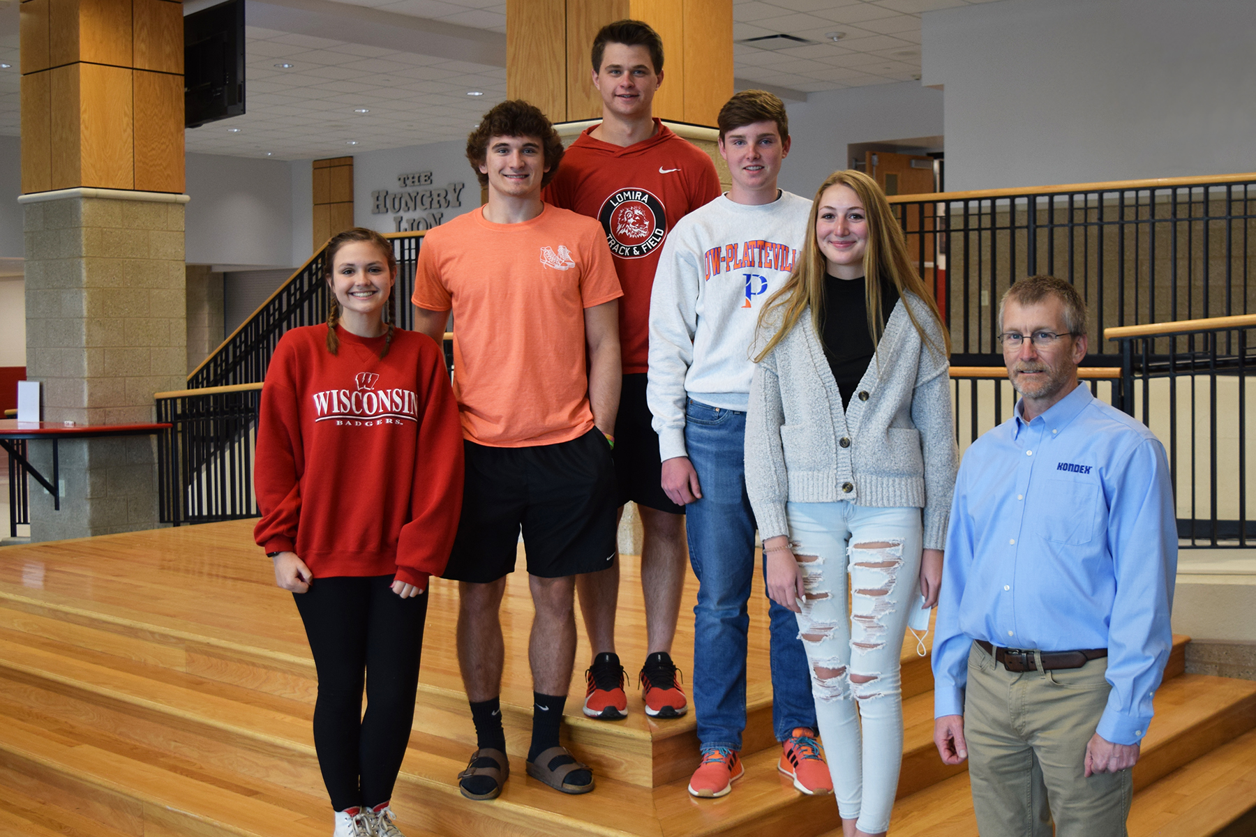 Five Lomira High School students standing on stairs with Kondex President Keith Johnson