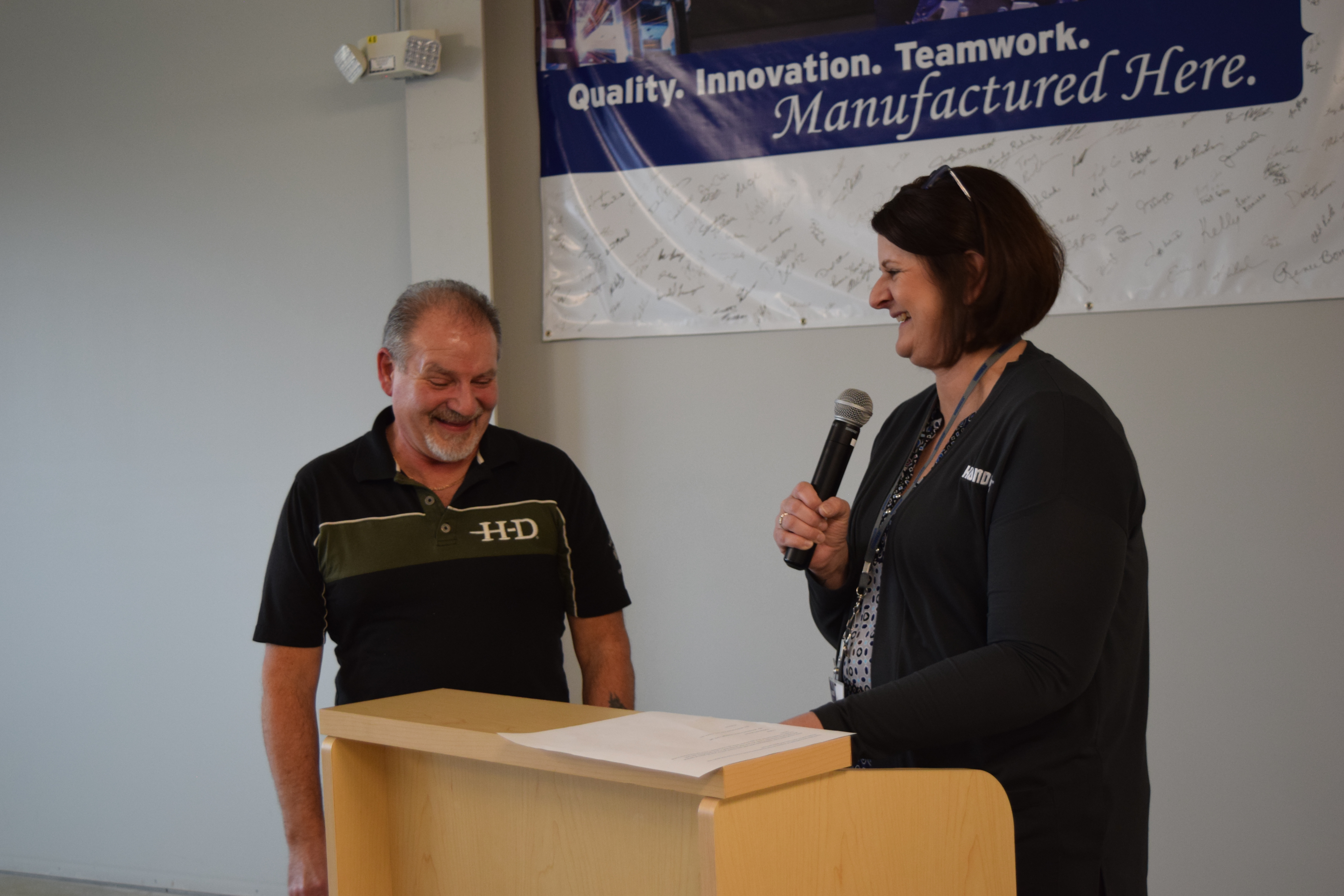 Kelly presenting Jesse with gifts at the podium