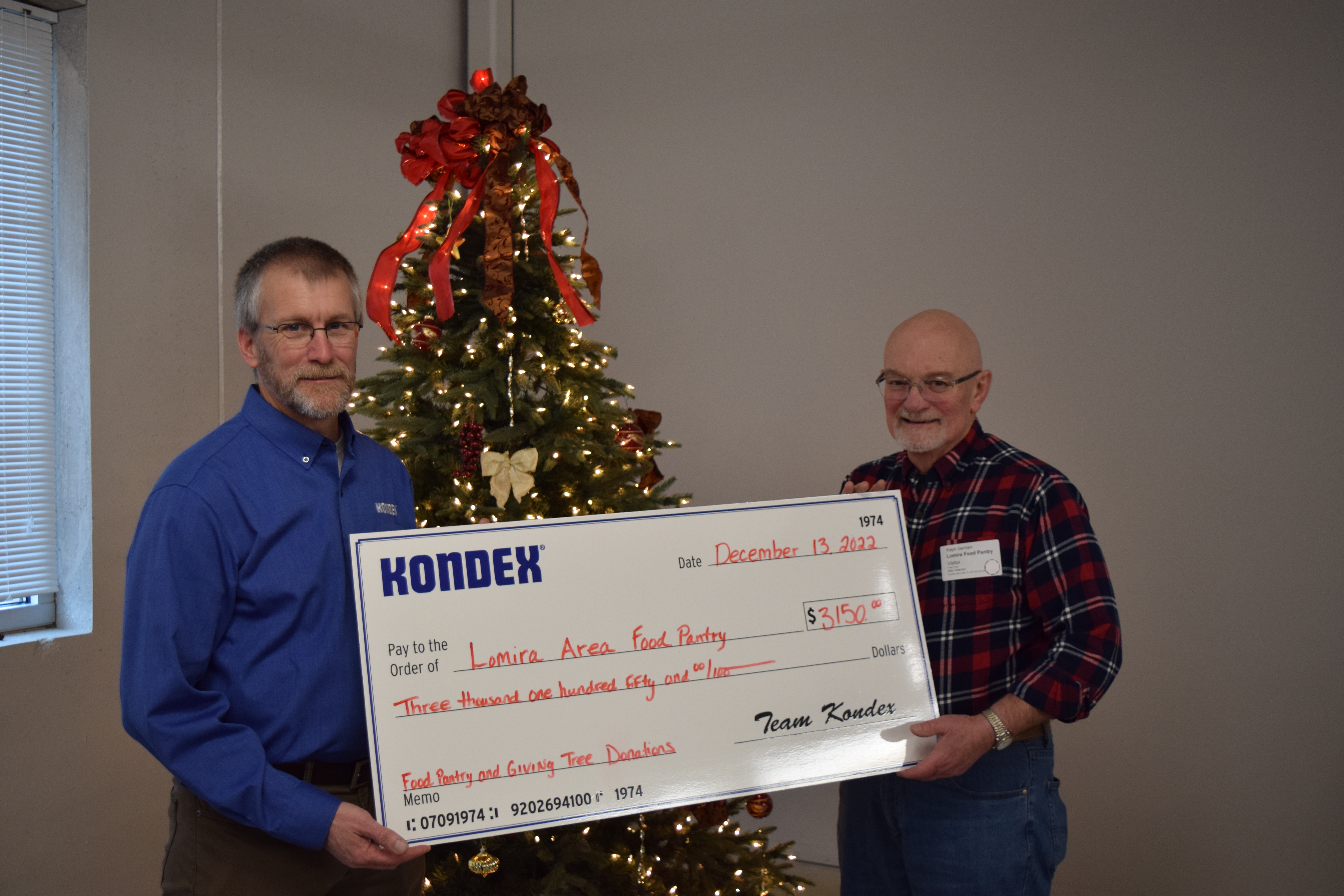 Kondex President Keith Johnson standing next to Ralph Germain holding large check