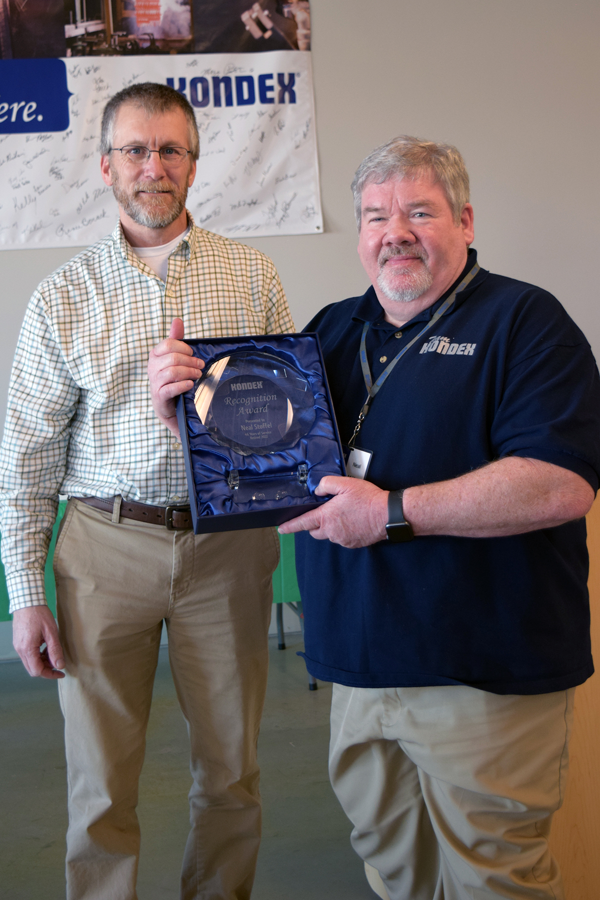 Stoffel holds a retirement plaque alongside Kondex President Keith Johnson